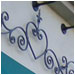 Ornamental scroll work and a canvas awning dress up this storefront.
